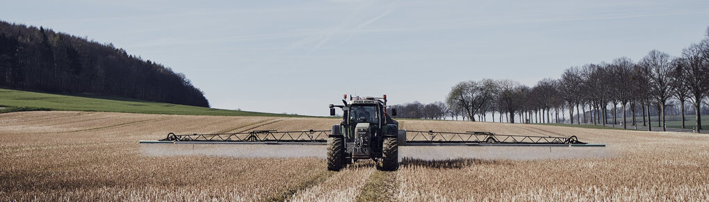 Glyphosat ist ein Pestizid: Ein Traktor fährt über ein Feld und bringt Glyphosat aus.