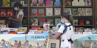 Zwei Frauen an einem Kinderbuchstand mit vielen bunten Büchern