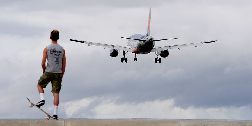 Mann läuft, am Himmel fliegt ein Flugzeug