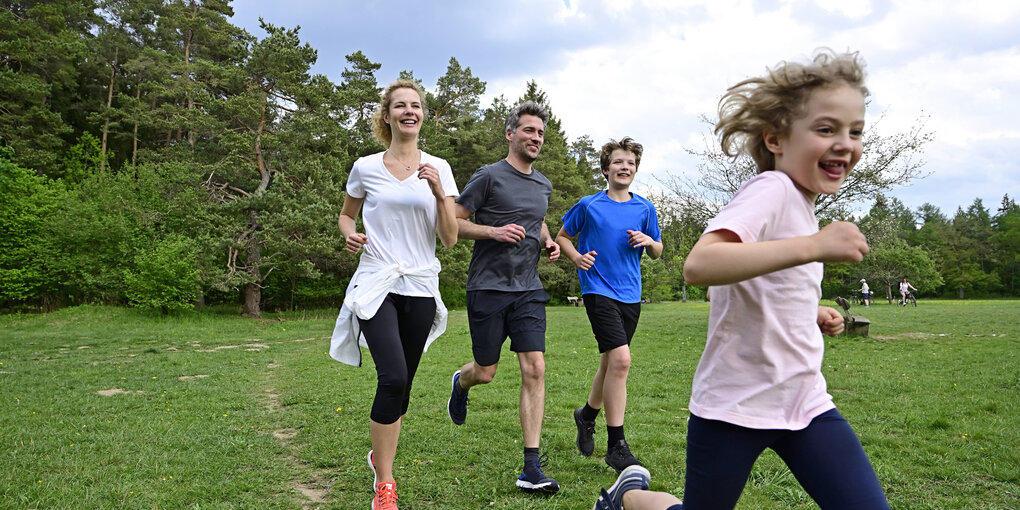 Eltern mit ihren 2 Kinder beim Joggen