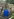 Eine blaue Regentonne steht an einer Mauer