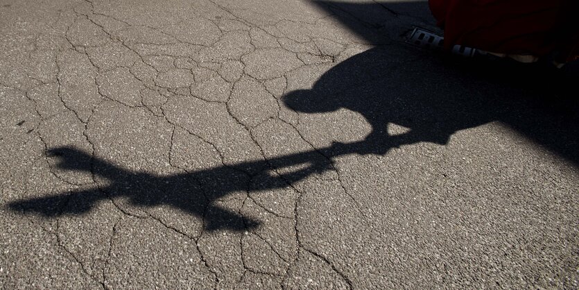 Der Schatten eines Priesters ist zu sehen, der am Karfreitag vor dem Circolo Krankenhaus in Italien einen Kreuzweg geht.