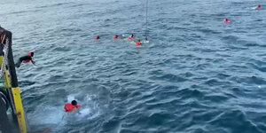 Geflüchtete springen von Bord der Open Arms um nach Palermo zu schwimmen