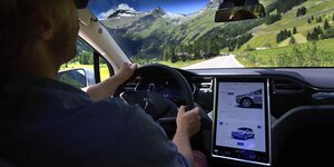 Blick in den Innenraum eines Tesla-Autos mit Fahrer und Bildschirm