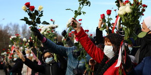 Menschen mit Blumen während eines Gedenkgottesdienstes für den Verstorbenen Roman Bondarenko