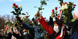 Menschen mit Blumen während eines Gedenkgottesdienstes für den Verstorbenen Roman Bondarenko