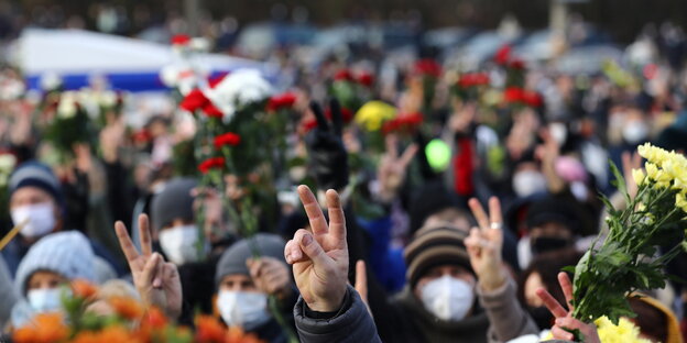 Anteilnahme bei der Beerdigung von Roman Bondarenko am Freitag in Minsk. Menschen halten Blumen und machen das Victory Zeichen.