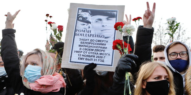Menschen mit einem Bild Roman Bondarenko während einer Gedenkveranstaltung in Minsk