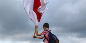 Ein Junge schwenkt eine rot-weiße Flagge