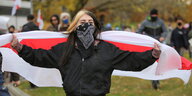 eine demonstrantin hält eine belarusisch e fahne hioch