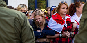 Frauen haben einader untergehakt, eine schreit