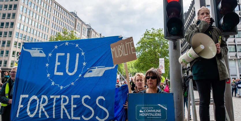 Ein Frau am Megaphon bei einer Demonstration gegen die Festung Europa