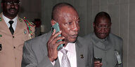 Guineas Präsident Alpha Condé trägt einen Anzug und telefoniert