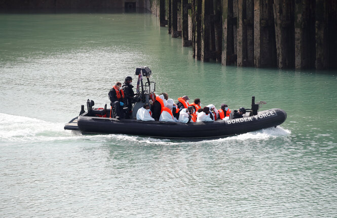 Ein Boot der Küstenwache trasportiert Menschen mit Schwimmwesten.