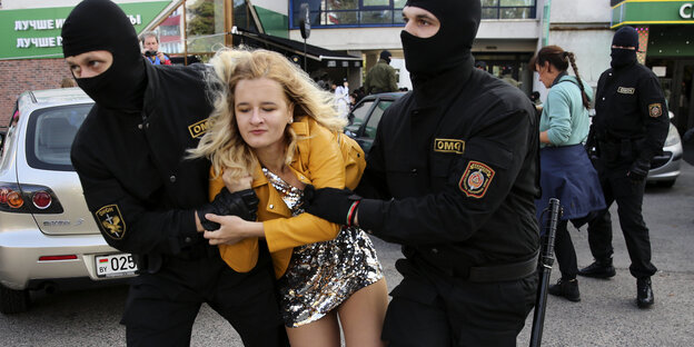 Belarus, Minsk: Polizeibeamte tragen eine Frau am Rande einer Demonstration gegen die Wahlergebnisse in Belarus weg