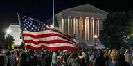 Menschen mit US-Flagge vor dem Supreme Court