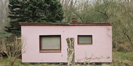 Ein rosafarbenes einfaches Wohnhaus im Grünen