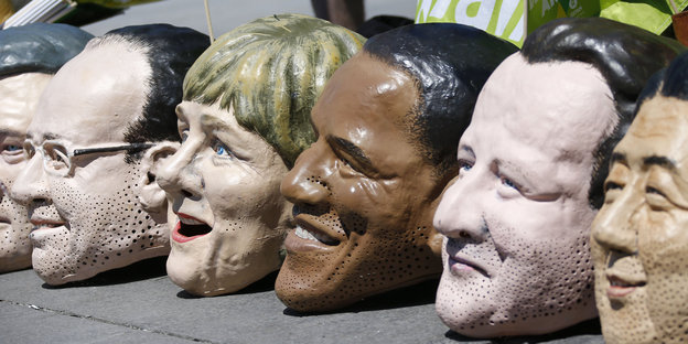 Masken der verschiedenen Staats- und Regierungschefs beim Protest gegen G7