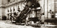 Eine Dampflokomotive bricht durch die Wand eines Bahnhofs