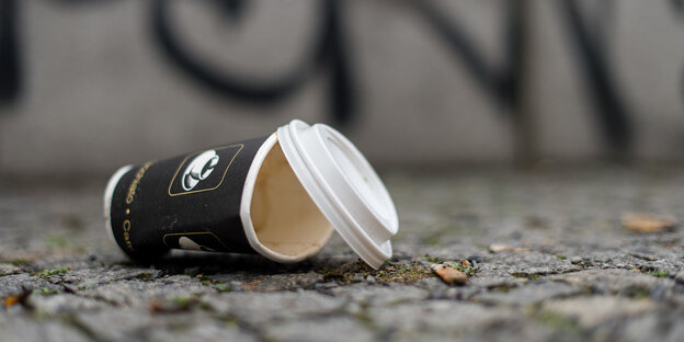 Plaste-Kaffeebecher liegt auf dem Boden