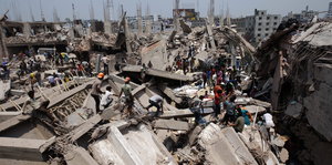 Rettungsarbeiter auf den Trümmern der eingestürzten Fabrik in Bangladesch
