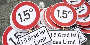 Auf dem Boden liegen Schilder mit der Aufschrift 1,5 Grad ist das Limit