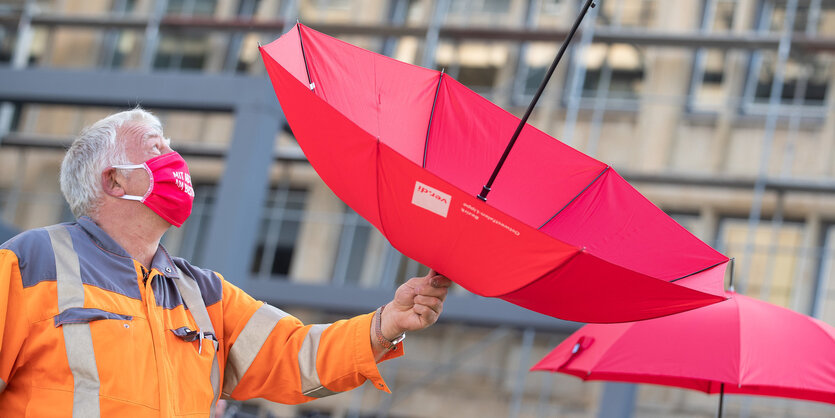 Eine Person hält einen Regenschirm an seiner Spitze in die Luft