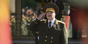 Präsident Alexander Lukaschenko in Armeeuniform salutiert