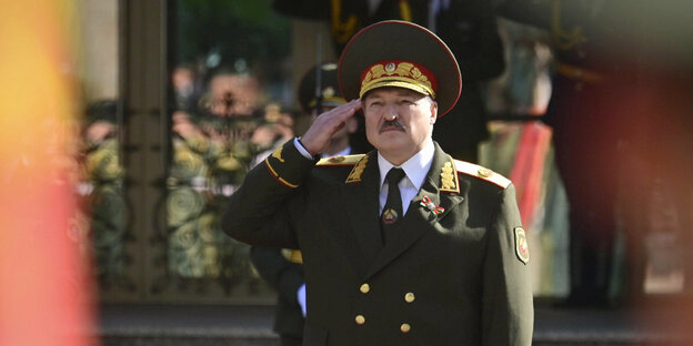 Präsident Alexander Lukaschenko in Armeeuniform salutiert