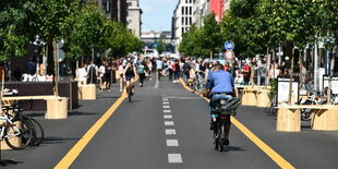 Die Friedrichstraße mit breitem Fußgänger- und Radweg, umgeben von Bäumen. Für Autos gesperrt.