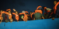 Flüchlinge mit orangenen Schwimm westen auf einem Seenotrettungsschiff