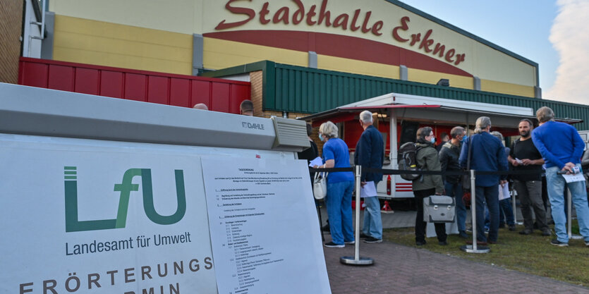 Menschen stehen vor der Stadthalle in Erkner