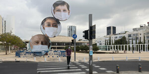 Ein Platz in Tel Aviv ist menschenleer, nur Werbebanner für einen Mundschutz ist zu sehen