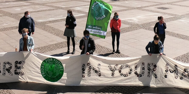 Klimaaktivist:innen mit Transparent auf dem Rathausmarkt