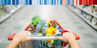 Ein voller Einkaufswagen zwischen Supermarktregalen