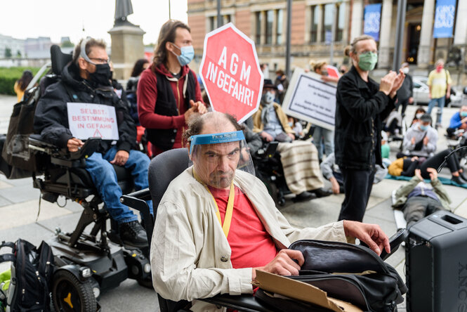 Menschen mit Assistenzbedarf legen sich auf den Platz vor dem Abgeordnetenhaus