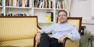 Philosoph Markus Gabriel sitzt in einem Sessel vor einem Bücherregal