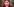 Potrait einer Frau, die eine rot-weiß gestreifte Mundschutzmaske trägt