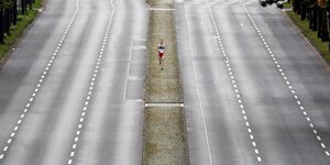 Mann lüft alleine auf der Straße des 17. Juni in Berlin