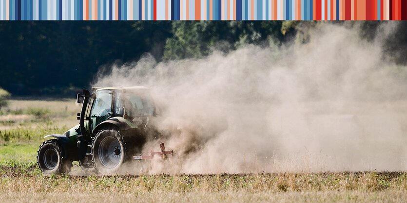 Ein Traktor fährt über ein ausgedörrtes Feld.