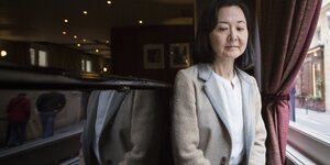 Die japanische Schriftstellerin Yoko Ogawa sitzt an einem Fenster
