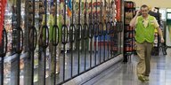 Ein Mitarbeiter von Walmart läuft an einer Reihe Kühlschränken entlang
