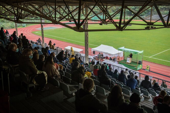 Menschen stehen auf einer tribüne im Stadion