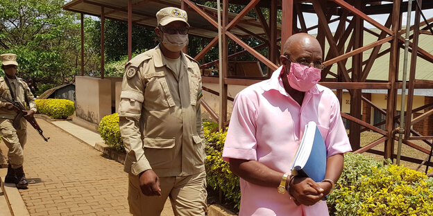 Paul Rusesabagina mit Maske in Begelitung von zwei Soldaten
