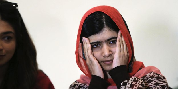 Malala Yousafszai hält die Hände vors Gesicht