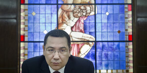 Victor Ponta vor einem Kirchenfenster.