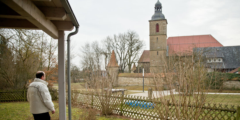 Syrischer Flüchtling blickt auf Kirche in Bayern