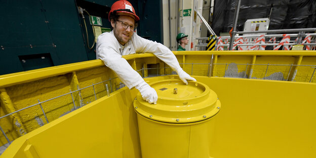 Minister Jan Philipp Albrecht hält bei einem Besuch im Kernkraftwerk Brunsbüttel den Deckel eines leeren Fasses für Atommüll.