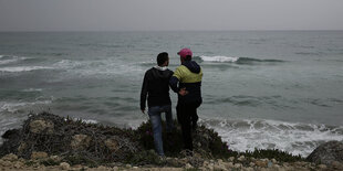 Zwei Männer stehen am Meer