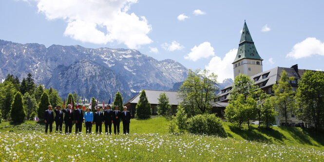 Menschen stehen vor Bergpanorama